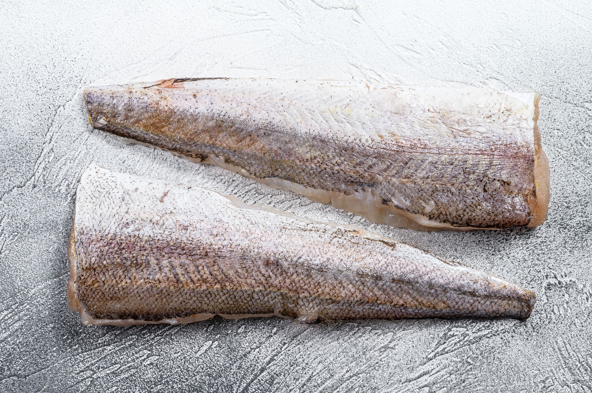 Filet cru de poisson merlu. Fond blanc. Vue supérieure