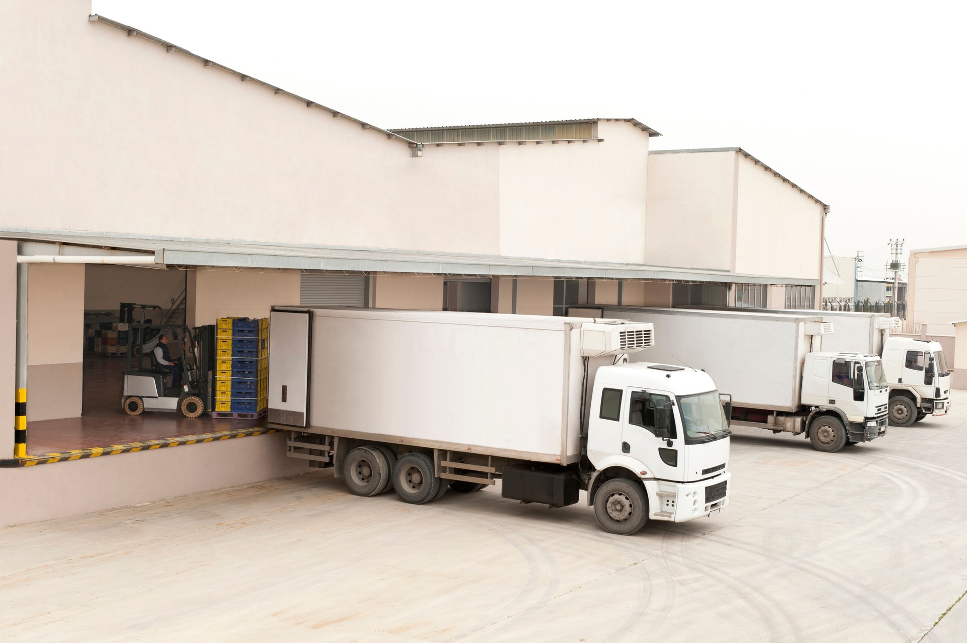Trois blanc camions en face de l'entrepôt